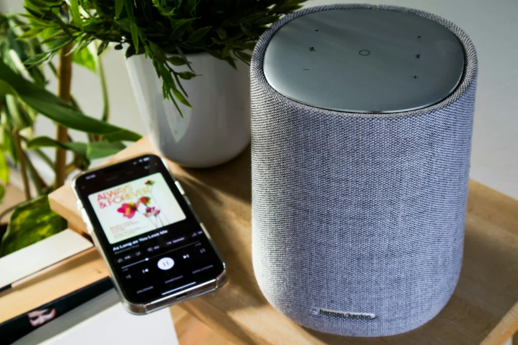 A smartphone is connected to a cylinder speaker.